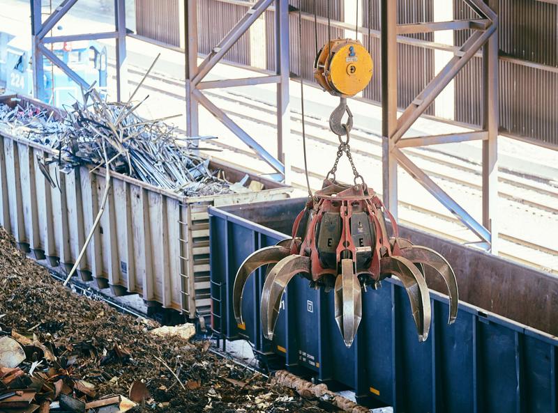 Grab loading scrap metal into an open container