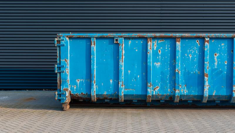 Large roll-on roll-off container against a metal-clad building