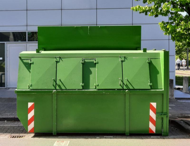Lidded enclosed skip on a paved street